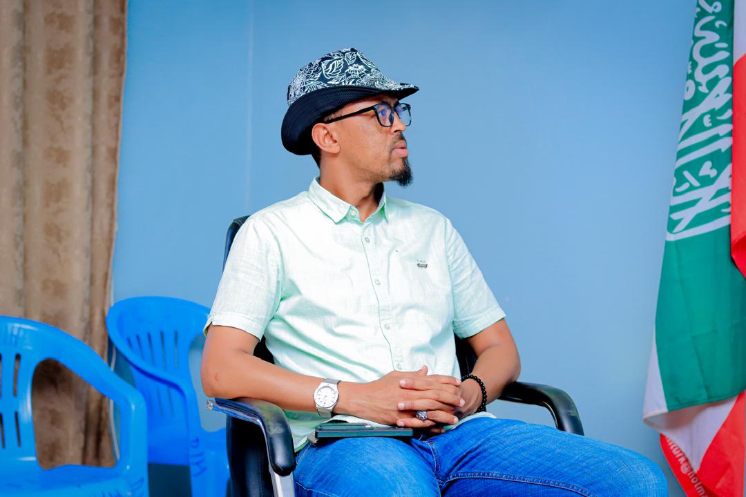 Participant seated beside the Somaliland flag during a training session